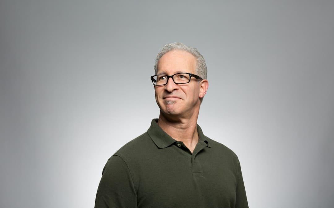 Older man with glasses and gray hair in a green polo